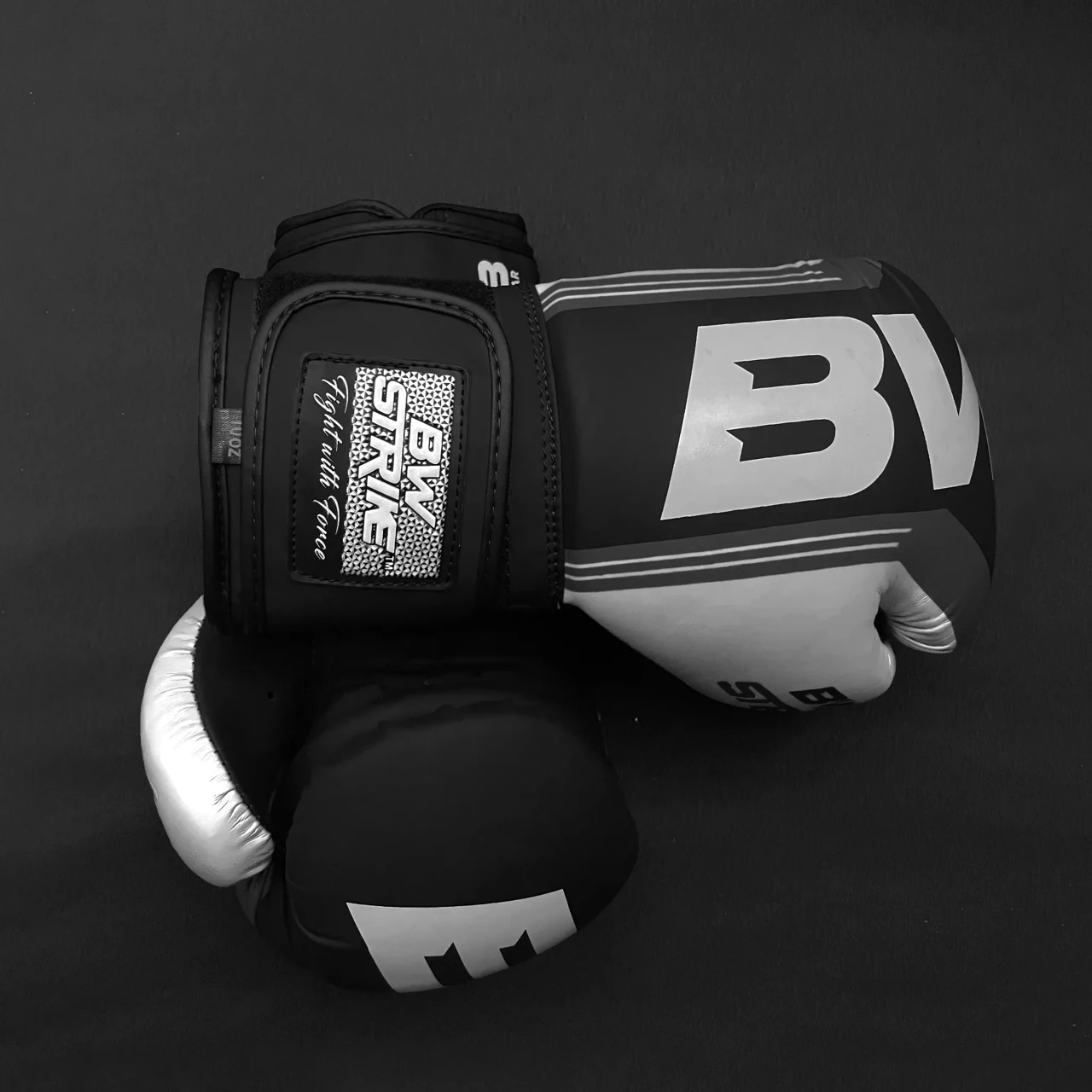 BW Strike product photography — Black and white glove product arrangement